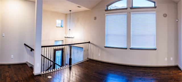 empty room featuring visible vents, baseboards, and hardwood / wood-style flooring