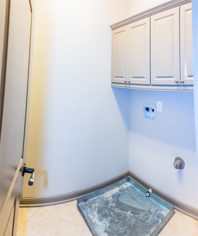 laundry room with hookup for a washing machine, cabinet space, baseboards, and light tile patterned flooring