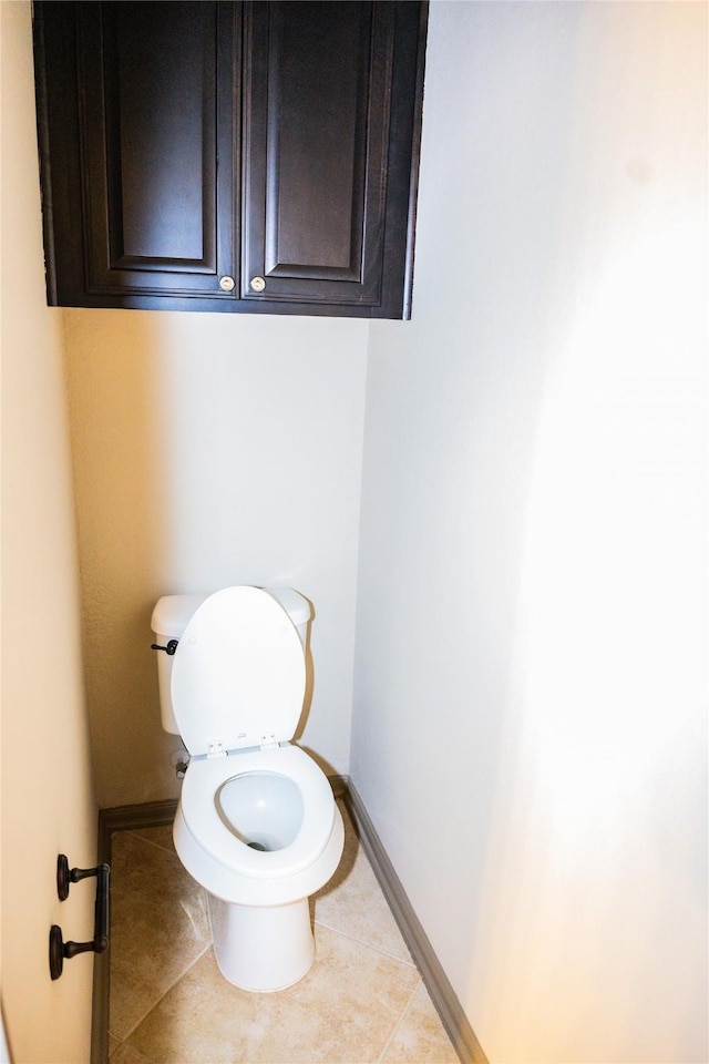 bathroom with baseboards, toilet, and tile patterned floors