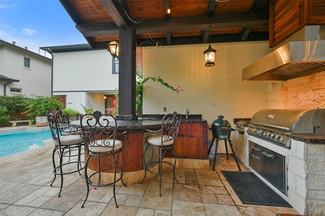 view of patio featuring an outdoor pool, a grill, an outdoor kitchen, and outdoor wet bar