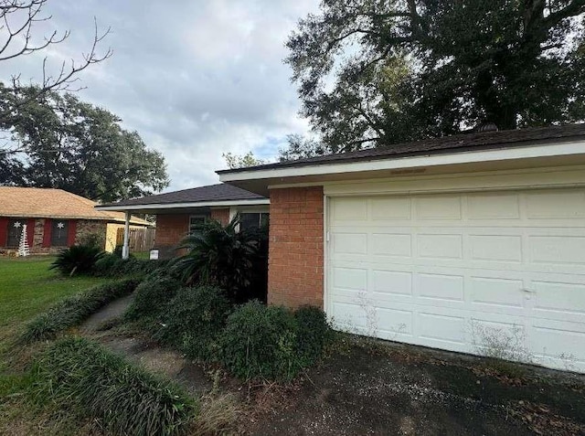 exterior space with a garage and brick siding