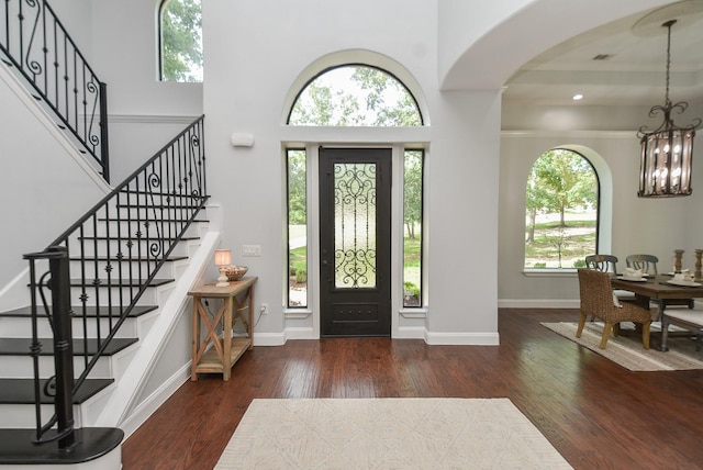 entrance foyer with dark wood-style floors, baseboards, and an inviting chandelier