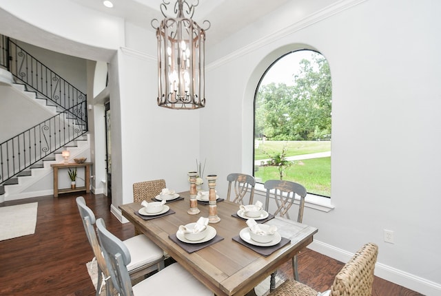 dining area featuring arched walkways, a chandelier, dark wood-style flooring, baseboards, and stairs