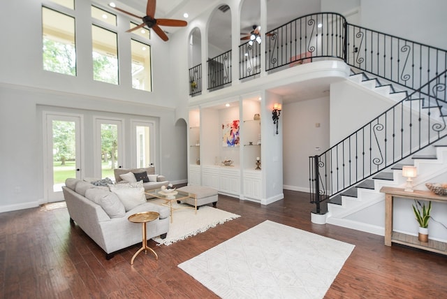 living room featuring dark wood-style floors, baseboards, and arched walkways