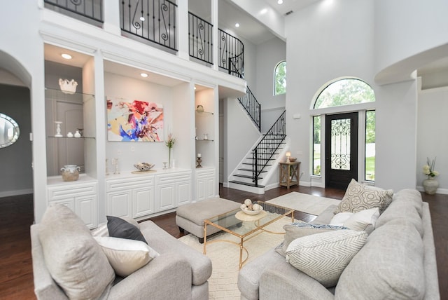 living room featuring baseboards, stairway, dark wood finished floors, and built in features