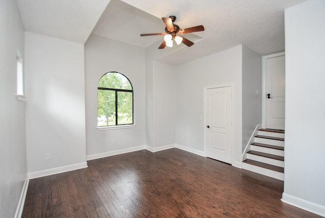 unfurnished room featuring dark wood-type flooring, baseboards, and a ceiling fan