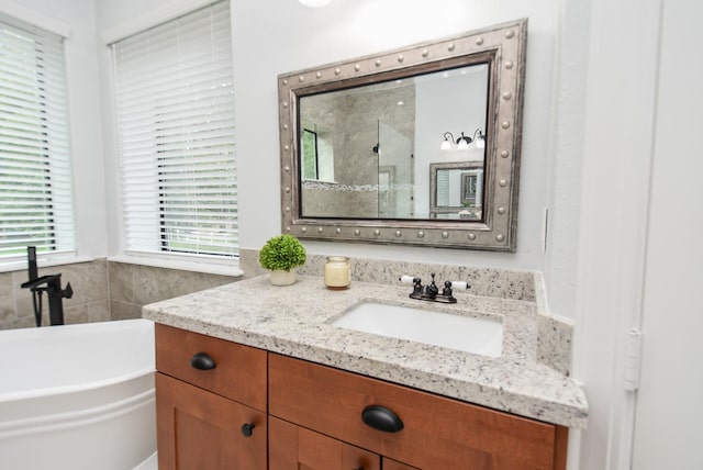 full bathroom featuring a garden tub and vanity