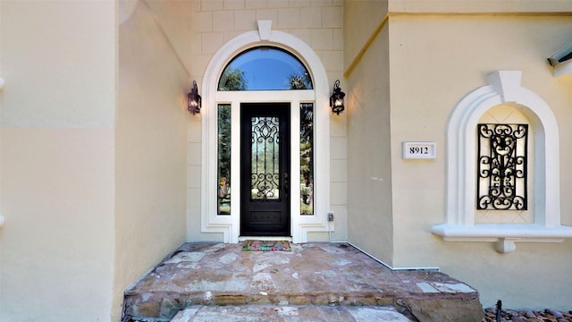 entrance to property featuring stucco siding