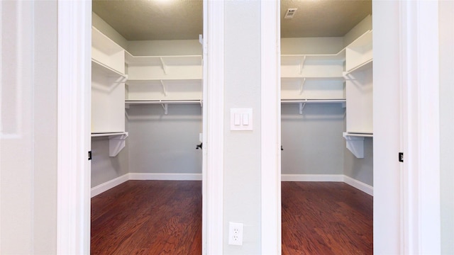 walk in closet with dark wood-style flooring