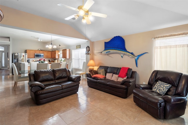 living area with lofted ceiling, light tile patterned floors, and ceiling fan with notable chandelier