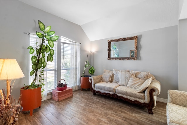 living room with baseboards, vaulted ceiling, and wood finished floors