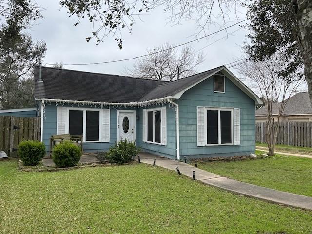 view of front facade featuring fence and a front lawn