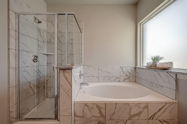 bathroom featuring a shower stall and a bath