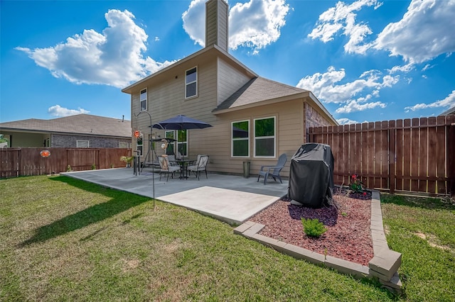 rear view of property featuring a patio, a lawn, a chimney, and a fenced backyard