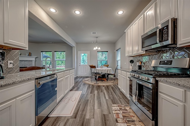 kitchen with light wood-style floors, white cabinetry, appliances with stainless steel finishes, and a sink