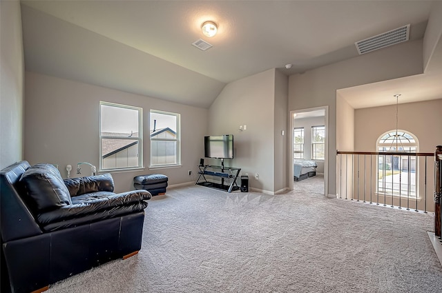 carpeted living area featuring baseboards, visible vents, and vaulted ceiling