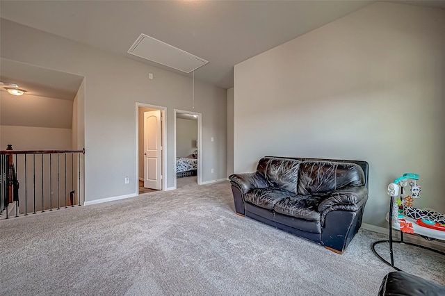 sitting room featuring attic access, lofted ceiling, light carpet, and baseboards