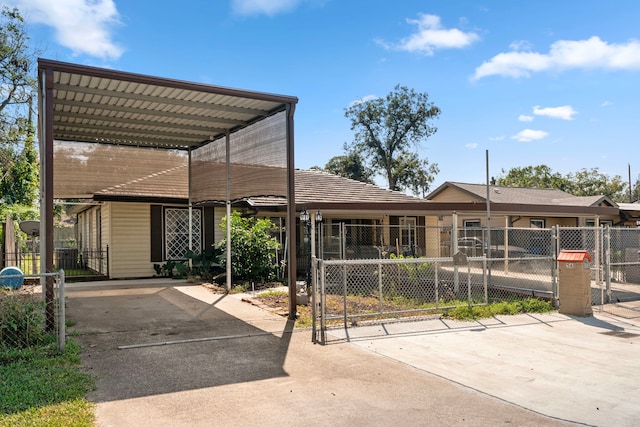 view of front of property with a fenced front yard, a detached carport, and a gate