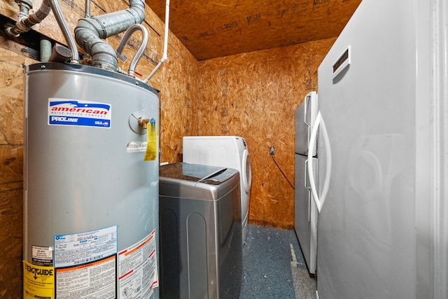 clothes washing area featuring laundry area, washer and clothes dryer, and gas water heater