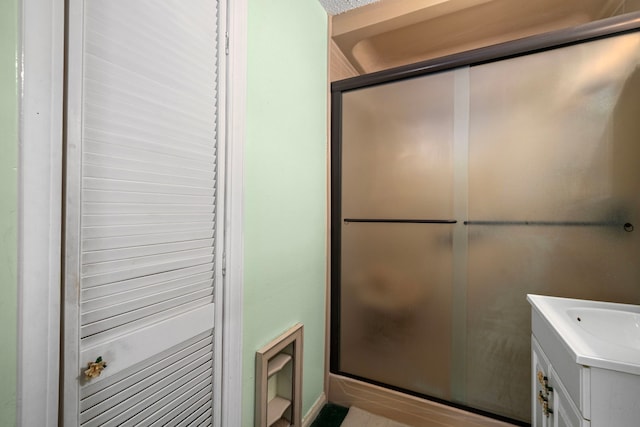 full bath with a shower stall and vanity