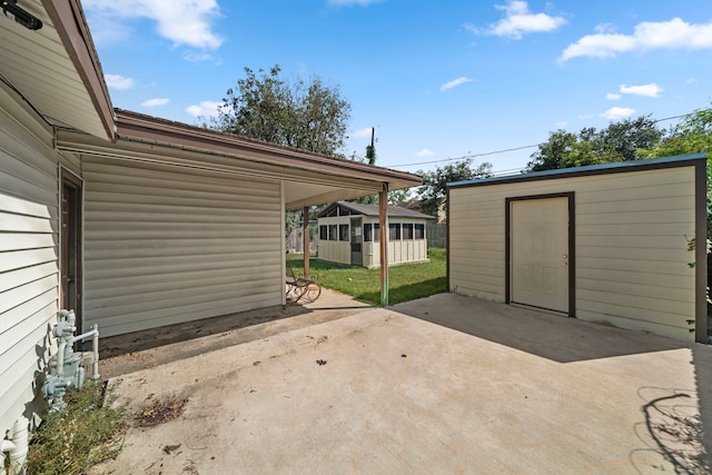 view of patio / terrace with an outdoor structure and a shed