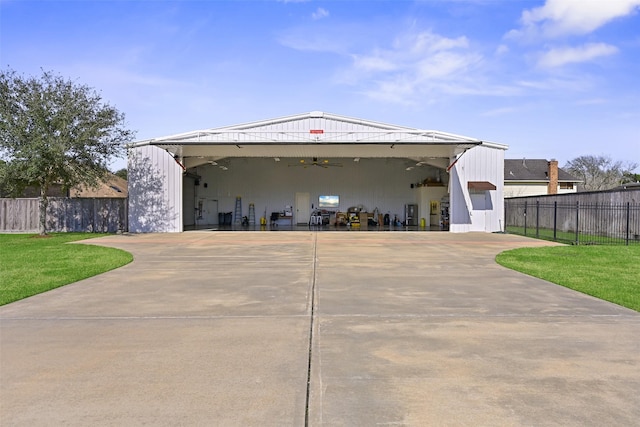 view of front of house featuring a garage, fence, a front lawn, and a ceiling fan