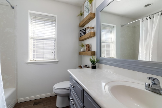 bathroom featuring plenty of natural light, baseboards, wood finished floors, and vanity