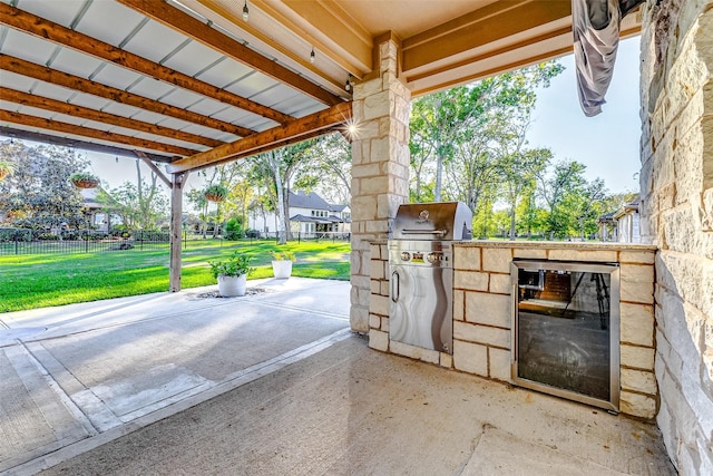 view of patio with fence, grilling area, and exterior kitchen