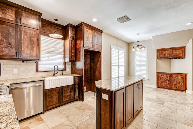 kitchen with visible vents, dishwasher, light stone counters, decorative light fixtures, and a sink