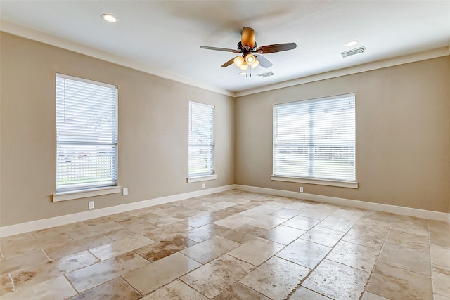 spare room with a wealth of natural light, visible vents, and baseboards