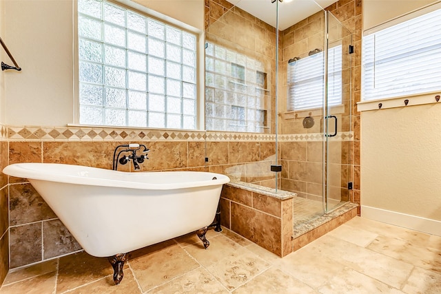 bathroom featuring stone finish flooring, a soaking tub, a shower stall, and tile walls