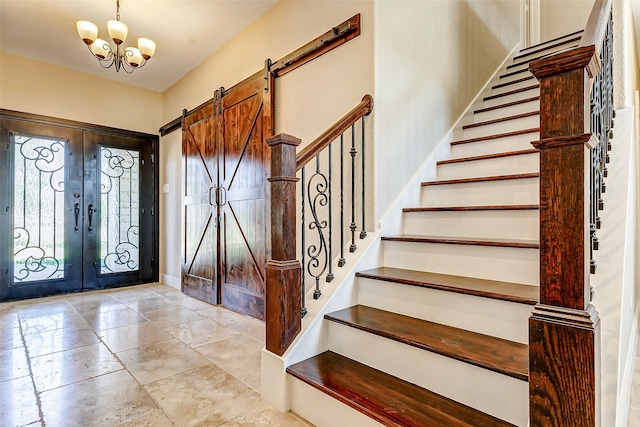 foyer with a barn door, baseboards, stairway, an inviting chandelier, and french doors