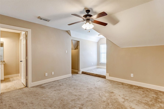 bonus room with light colored carpet, visible vents, a ceiling fan, vaulted ceiling, and baseboards