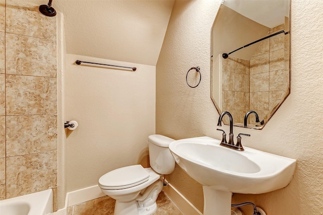 bathroom featuring a textured wall, tile patterned flooring, toilet, a sink, and  shower combination