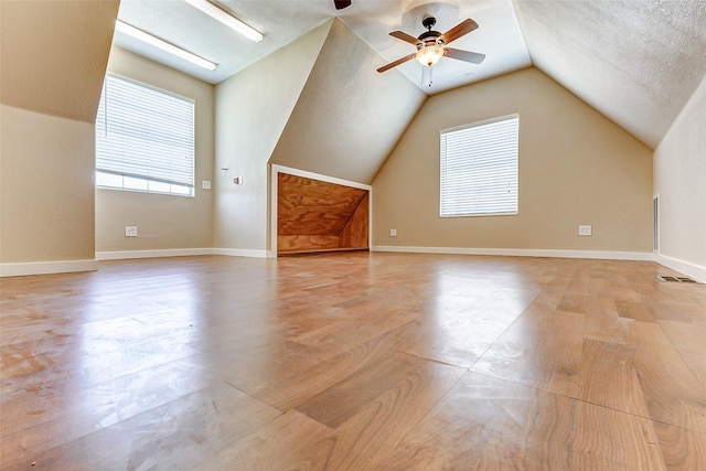 additional living space featuring baseboards, visible vents, and vaulted ceiling