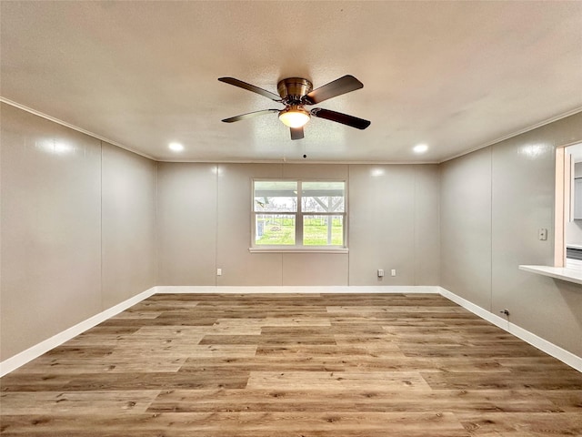 empty room with light wood finished floors, recessed lighting, ornamental molding, ceiling fan, and baseboards