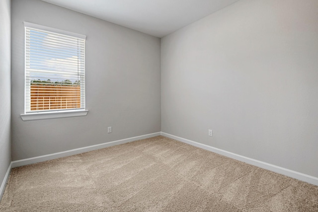 spare room featuring carpet flooring and baseboards