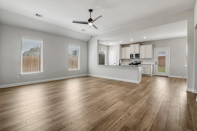 unfurnished living room with recessed lighting, visible vents, light wood-style floors, ceiling fan, and baseboards