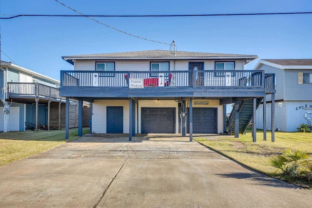 view of front of house with a front yard, a wooden deck, stairway, and an attached garage