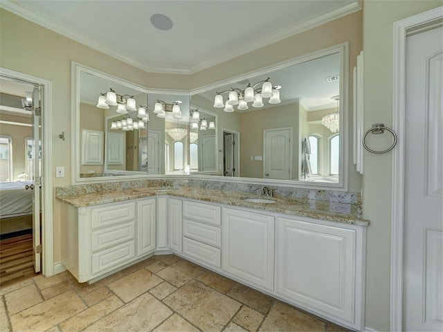 ensuite bathroom featuring a sink, ornamental molding, double vanity, ensuite bath, and stone tile flooring