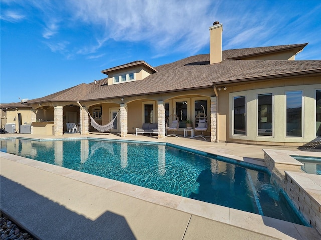 view of swimming pool featuring a pool with connected hot tub and a patio