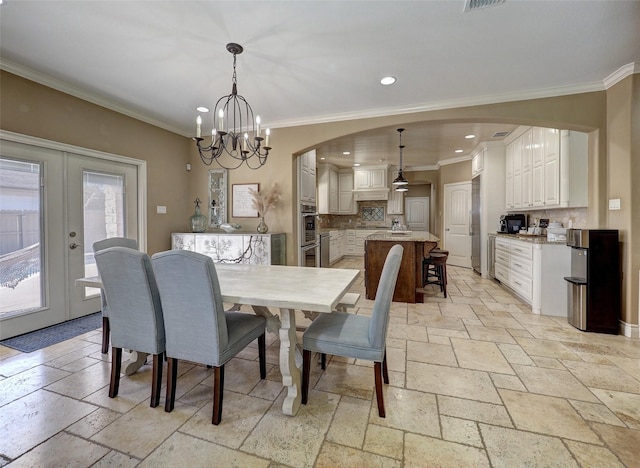 dining room featuring arched walkways, recessed lighting, stone tile floors, french doors, and crown molding