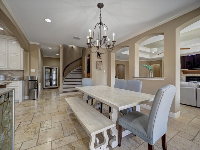 dining room featuring stone tile floors, visible vents, baseboards, ornamental molding, and recessed lighting