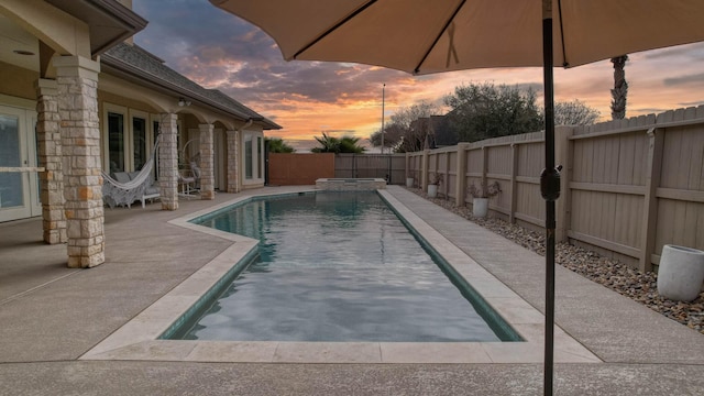 view of pool with a patio area, a fenced backyard, and a pool with connected hot tub