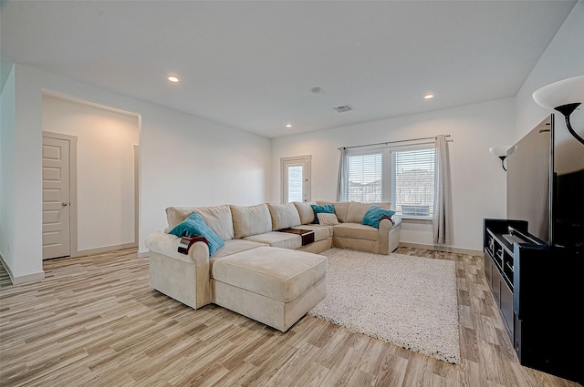 living area with recessed lighting, baseboards, visible vents, and light wood finished floors