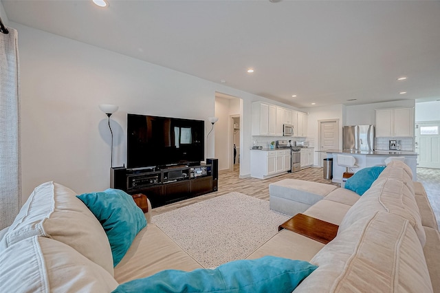 living room with light wood-type flooring and recessed lighting