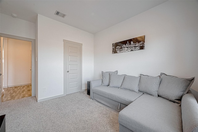 living room with carpet floors, baseboards, and visible vents