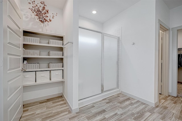 full bath with recessed lighting, a shower stall, baseboards, and wood finished floors