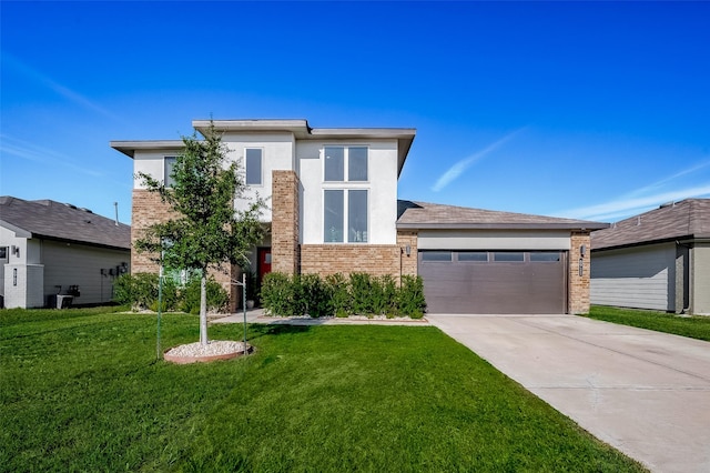 prairie-style home with a garage, concrete driveway, brick siding, and a front lawn