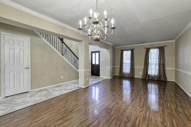 foyer with crown molding, stairway, a wealth of natural light, and wood finished floors